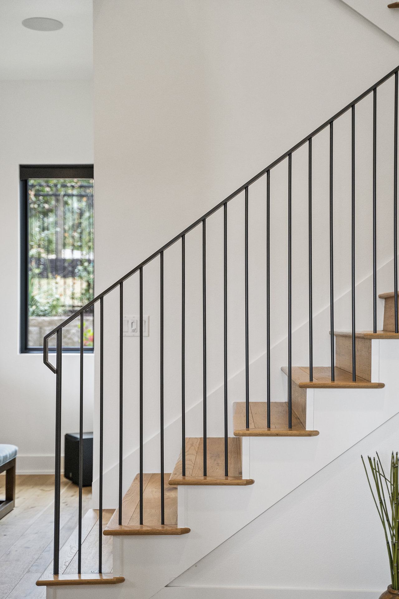 Curved staircase with a black iron railing, photographed from the landing